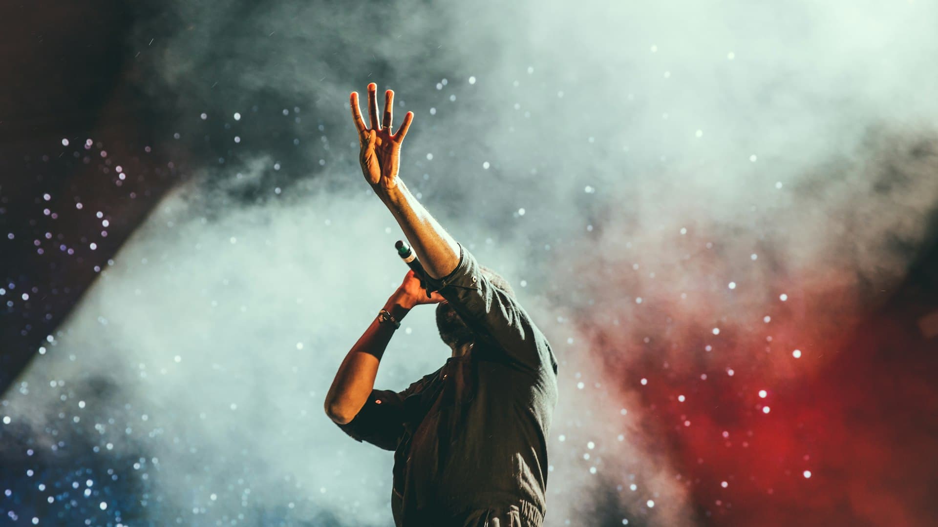 Cinematic crowd at a Happening Co. live event, silhouetted against stage lighting